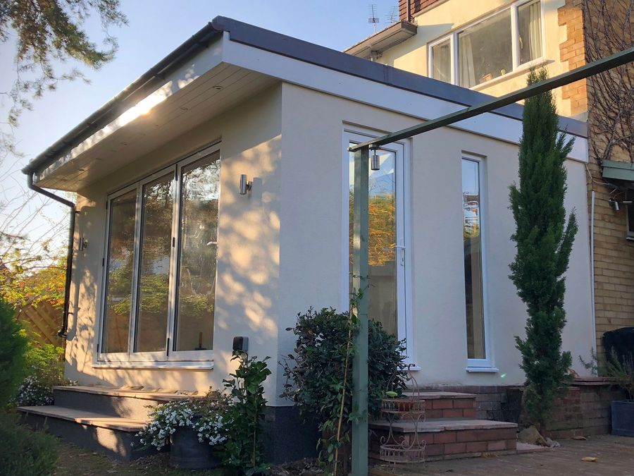 Finished white garden room with corner glazing in a landscaped garden