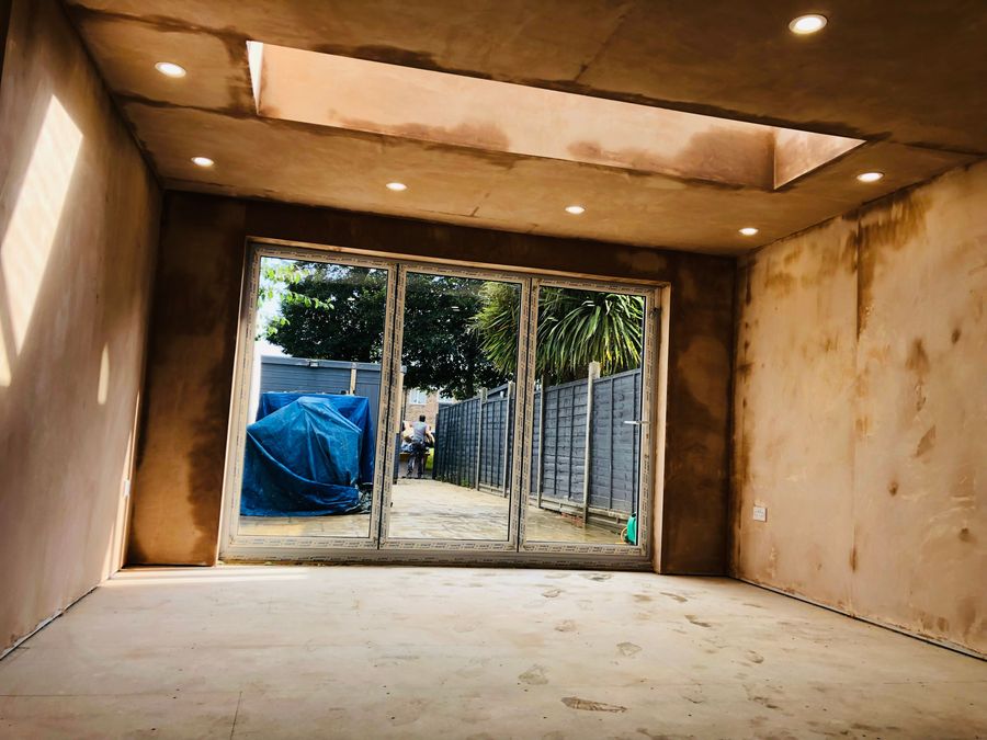 Freshly plastered extension interior with sliding doors before decoration
