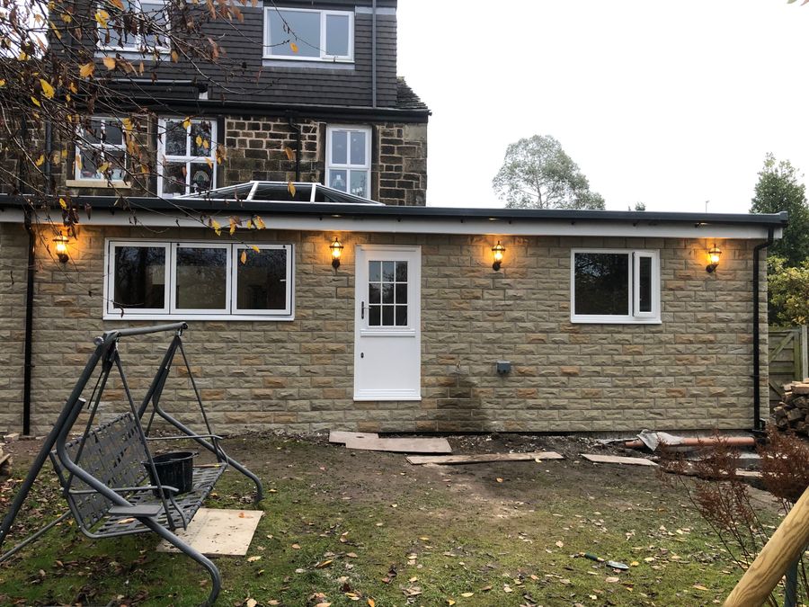 Stone cottage extension with white cottage-style windows and garden swing