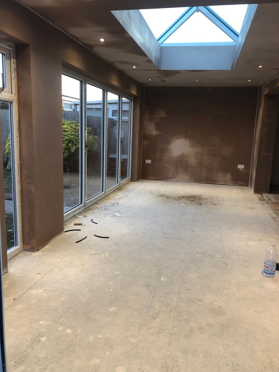 Extension shell during fit-out with glazed doors installed and floor prepared