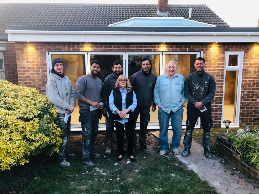 EazyBase installation team with homeowners outside a completed extension