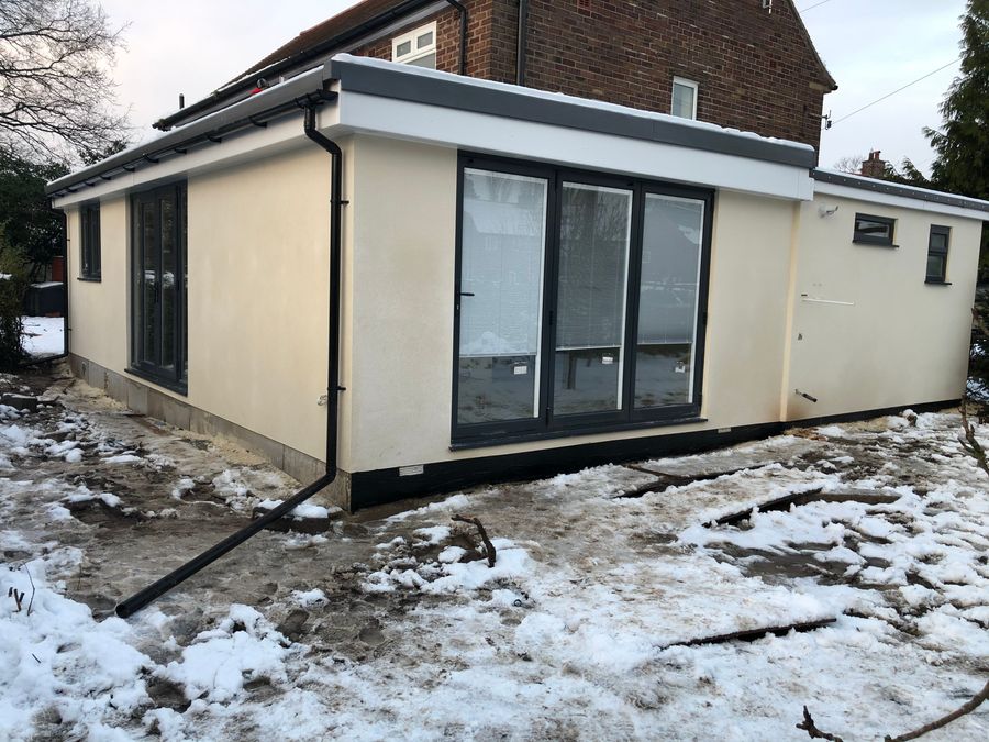 Newly installed modular extension with dark glazing in winter snow