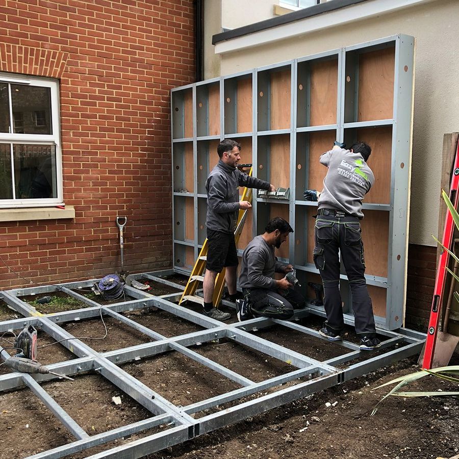 Installation team assembling the modular frame on the prepared base